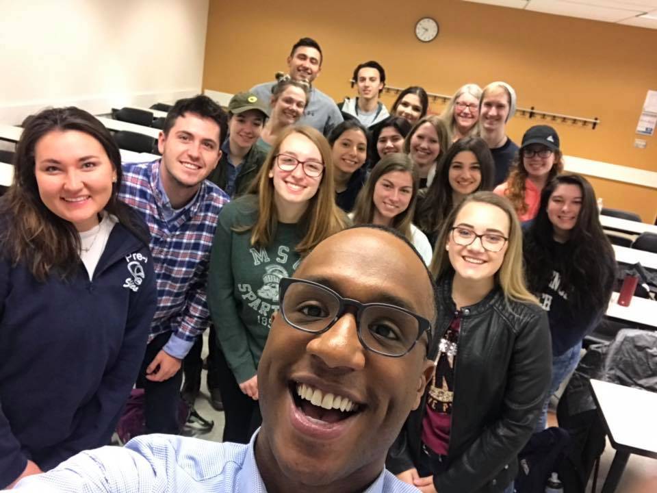 Marvis Herring takes a selfie with students of COM 201.10 in Winter 2019